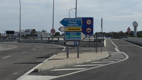 Malaga, Spain; 10/31/2020; Cars driving through the highway - Cars heading to Malaga - Malaga airport road sign - Malaga city road sign