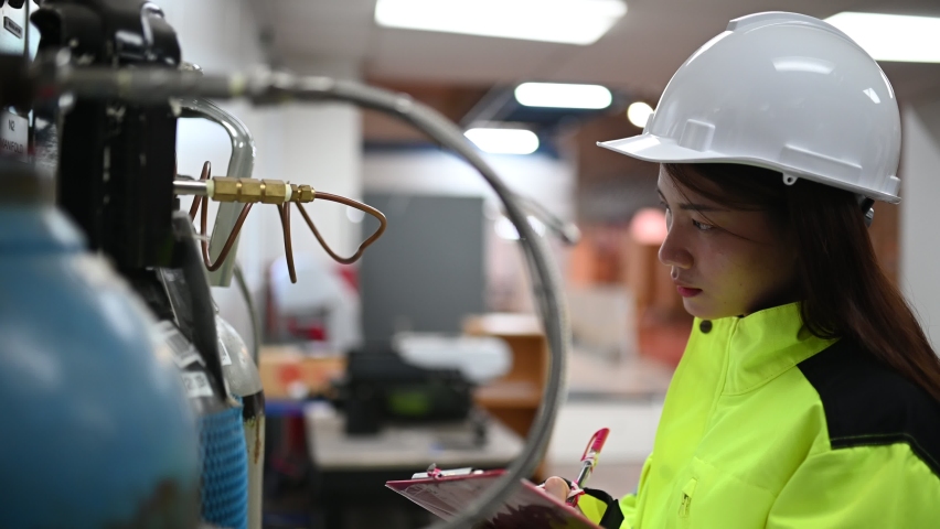 Asian engineer working at Operating hall,Thailand people wear helmet  work,He worked with diligence and patience,she checked the valve regulator at the hydrogen tank. | Shutterstock HD Video #1061597905