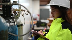 Asian engineer working at Operating hall,Thailand people wear helmet  work,He worked with diligence and patience,she checked the valve regulator at the hydrogen tank. - Powered by Shutterstock - Get 15% off with code: PIKWIZARD15