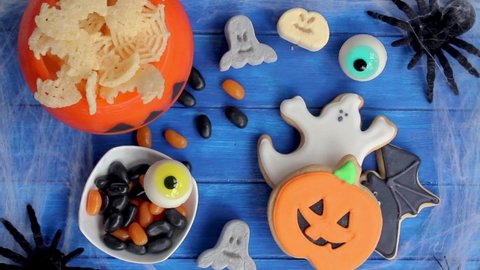 Women hands taking Halloween cookies from decorated table