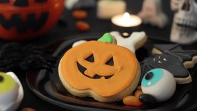 Close-up of woman hand taking a pumpkin cookie from halloween themed table - Powered by Shutterstock - Get 15% off with code: PIKWIZARD15