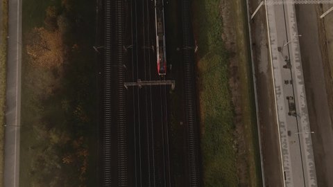 Trains passenger transport moving forward on railways in the city and camera from drone moves with one of city trains. Train top view.