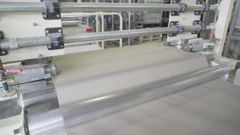 Rotation of a roll of paper on machine-tool or conveyor. Paper is fed onto a conveyor. Manufacture plasterboard sheets, drywall, gypsum board.