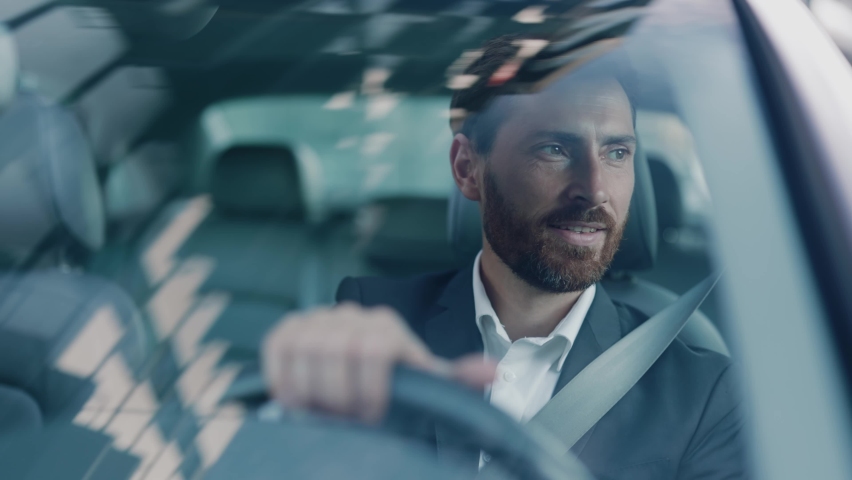 Handsome adult caucasian businessman in formal suit driving his car commuting to work. Business person. Successful people. Luxury lifestyle. Positive mood. Royalty-Free Stock Footage #1061608744