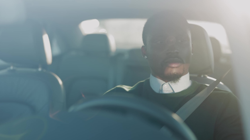 Attractive concentrated young african american man driving luxurious car fast through the city on business trip. Destination. Commuting. Private car transportation. Royalty-Free Stock Footage #1061608894