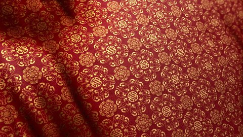 Traditional elegant Asian Double Happiness pattern in golden red color on waving looped cloth. Concept 3D animation shot for Chinese New Year and festive backgrounds. Luxurious full frame silk texture