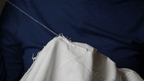 Woman Hands Sewing a white coat. Woman at work