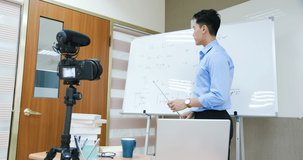 asian senior high school male teacher teach physical online through camera in classroom