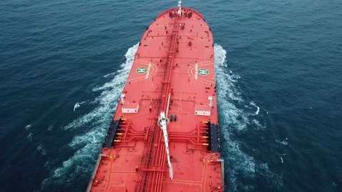 ISTANBUL - CIRCA 2019: Crude oil tanker passing under the camera in open sea. Bow, red upper deck, ballast tanks, pipe lines, cranes, wheelhouse, radar mast and stern of a supertanker. Flying over
