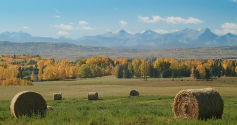 Autumn Prairies with Rocky Mountains Farm Field Reveal Mountains Green Grass Hay Bails County Lifestyle 4K
