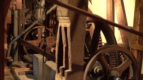 Spinning Cogwheels Gear Wheels with transmission in wooden old Mill