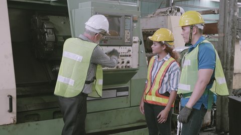 Group of engineer talking and training working using machine control together in industrial factory, foreman discussing and teaching trainee, people diversity, indoors, industry concept.