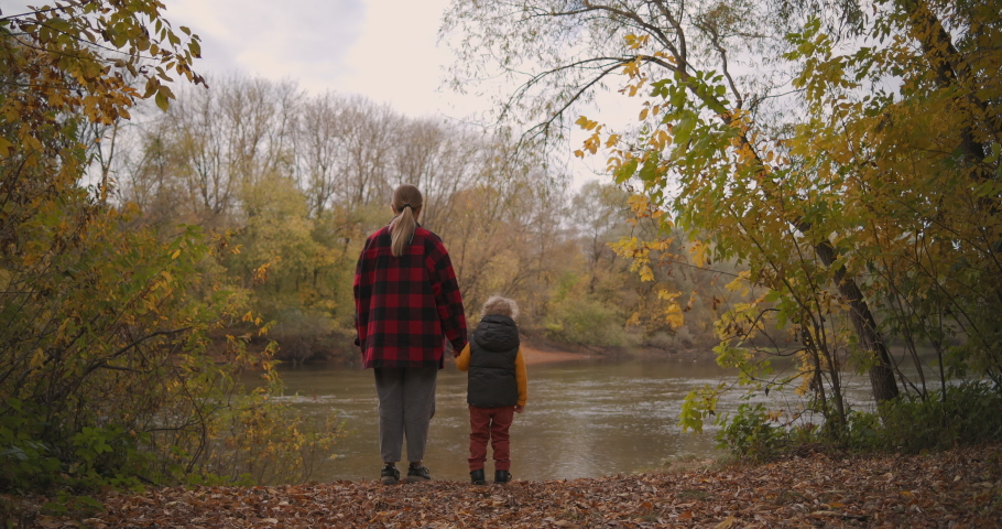 Woman is spending weekend with her little son at nature, walking in forest and viewing landscapes with lake, mother and child | Shutterstock HD Video #1061625580