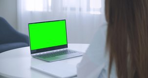 Woman doctor is consulting online, laptop with green screen on table, chroma key concept