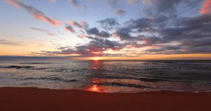 Ocean beach sunrise 4K video footage. Waves splash on the sea sand.
