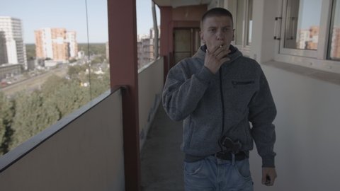 Caucasian Youth Smoking Cigarette in Inner-City High-Rise Residential Building 