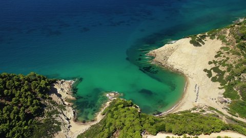 Aerial drone video of paradise emerald and turquoise sandy beach of Aselinos covered in pine trees in island of Skiathos, Sporades, Greece