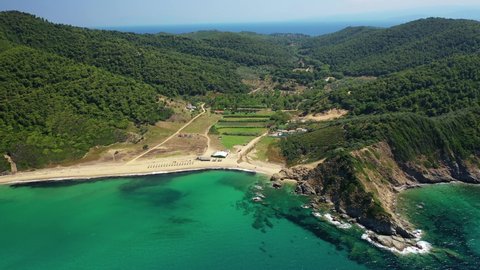Aerial drone video of paradise emerald and turquoise sandy beach of Aselinos covered in pine trees in island of Skiathos, Sporades, Greece
