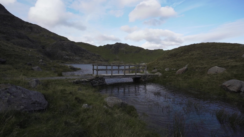 A man walking along a wooden bridge in Snowdonia National Park