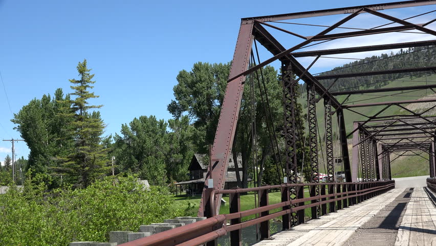 MADISON, MONTANA - JUN 2015: Drive POV historic Hutchins Bridge Madison River Montana 4K. Old Kirby Place long and colorful past of the Madison River Valley near Yellowstone National Park.