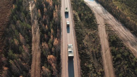 A military convoy is moving along the road. Aerial view.