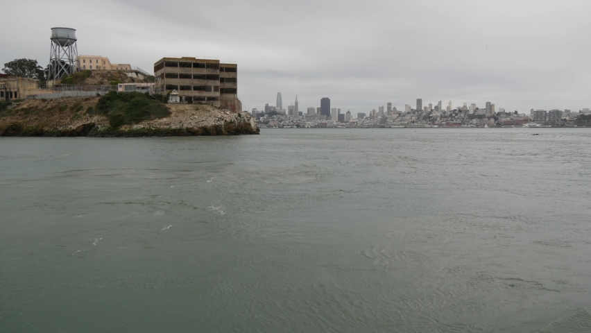 Alcatraz island in San Francisco Bay, California USA. Federal prison for gangsters on rock, foggy weather. Historic jail, cliff in misty cloudy harbor. Gaol for punishment and imprisonment for crime.