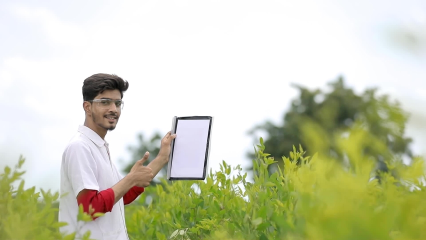 Young Indian agronomist collecting some information at field