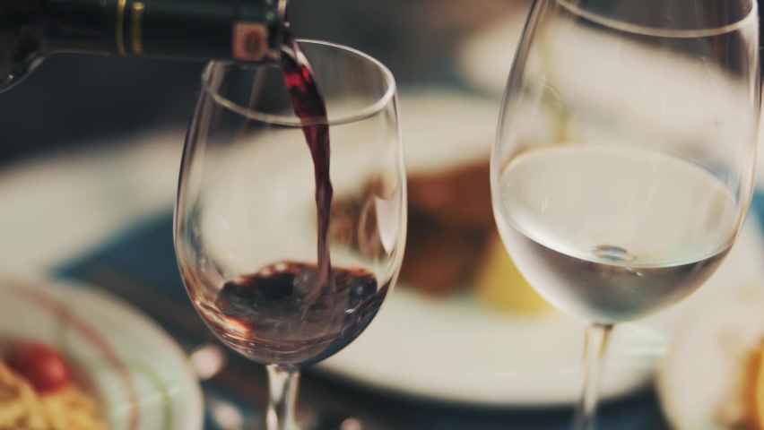 Red wine poured into a wine glass in a restaurant. | Shutterstock HD Video #1061656654