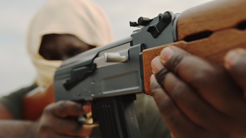concept of terrorism. Unrecognizable black man shooting with kalashnikov, ak-47 machine gun