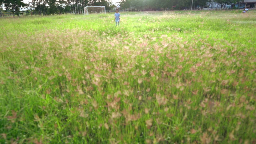 Slow motion kid running on grass field on sunny