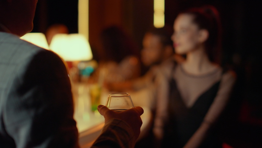 Young man drinking cognac at nightclub party. Beautiful woman having rest in bar at evening. Handsome man flirting with young woman in restaurant interior. Young couple dating at night club Royalty-Free Stock Footage #1061664283