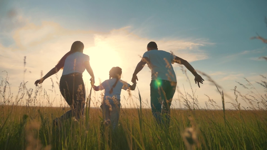 Happy family run in park at sunset. Teamwork. Parents and daughter are run at sunset. Silhouette of running happy family in park. Children are running. Silhouette of happy family in park Royalty-Free Stock Footage #1061665048