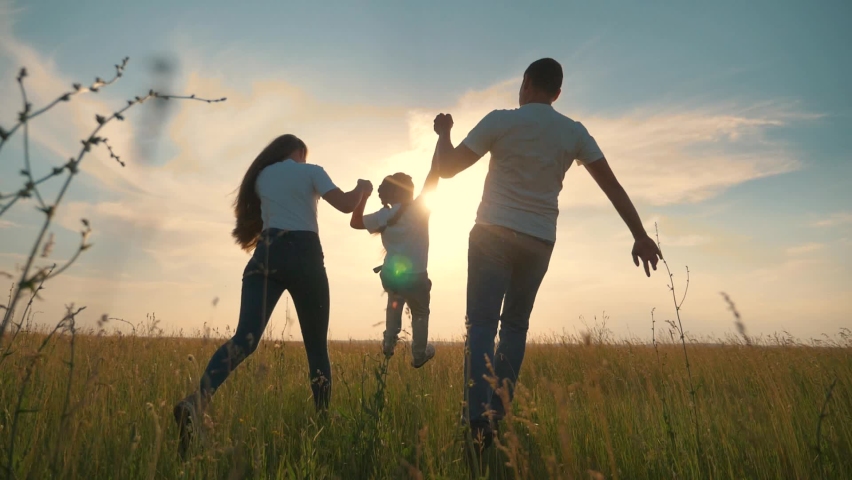 Happy family run in park at sunset. Teamwork. Parents and daughter are run at sunset. Silhouette of running happy family in park. Children are running. Silhouette of happy family in park | Shutterstock HD Video #1061665048