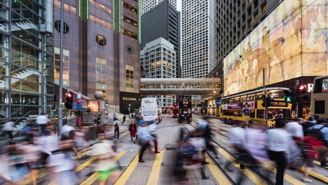 TL/ZO China, Hong Kong, 11-10-2019, Zoom In Time lapse of people crossing the road in the financial district, during evening rush hour, with traffic passing by.