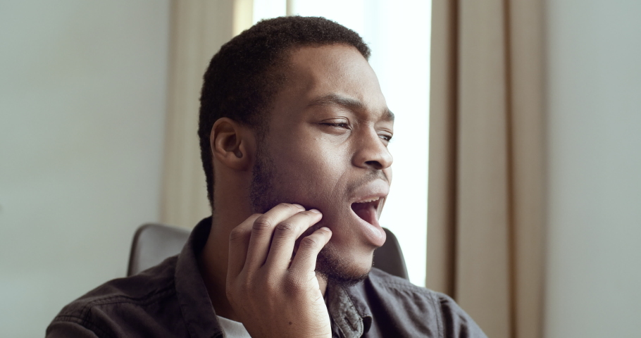 Portrait of afro american businessman feeling tooth pain. Sick black manager freelancer student guy touching his cheek and suffering from symptoms toothache needs dentist help, emotion of sadness | Shutterstock HD Video #1061668648
