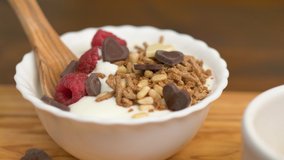 white yogurt with honet, cereal grain and fresh raspberries