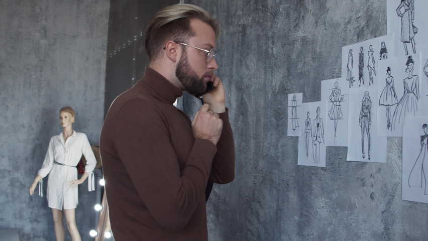 Workplace of young and talented fashion designer. Tailor works in stylish loft using sketches of clothes.