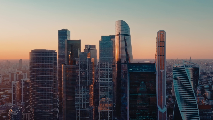 Moscow city glass skyscrapers drone pan circular shot right to left, cityscape with sunset horizon, reflection in the windows. Moscow International Business Center at the sunset, evening Royalty-Free Stock Footage #1061675059