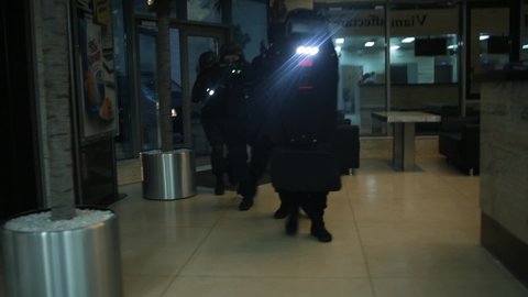 Сounter terrorist squad moves quickly, hiding behind a bulletproof shield.