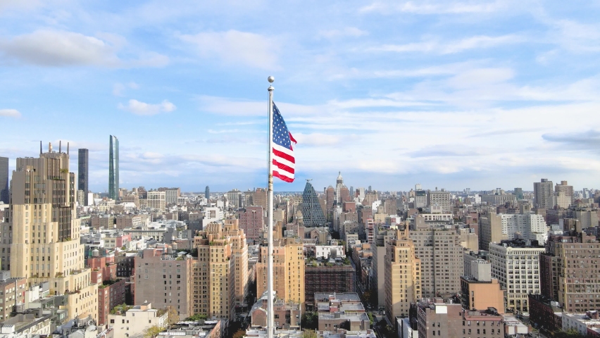 American USA flag waiving in the wind with New York City in the background. Royalty-Free Stock Footage #1061684572