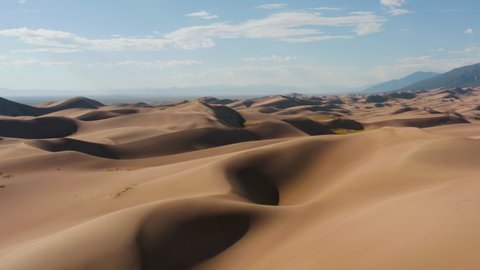 Aerial view over sandbanks, wasteland and endless desert, sunny day, in the Great sand dunes national park, in Colorado, USA - tilt up, drone shot