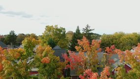 Rising aerial reveals traditional homes during autumn. American flag at front of house in United States, welcome friends and family home for Thanksgiving holiday. - Powered by Shutterstock - Get 15% off with code: PIKWIZARD15