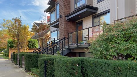 Establishing shot. Modern apartment building with stairs, balcony, trees and beautiful landscape in Vancouver, Canada, North America. Blue sky, clouds. Day time September 2020. Moving forward. H.264.