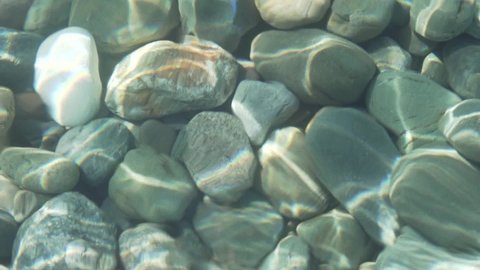 pebble or gravel and round stone beach in sea or flow river and pond with sea to clear transparent by clean water wave