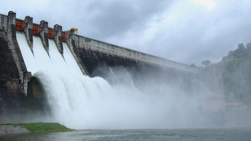 A large dam is draining because of heavy rain. The amount of water in the dam is too high. Royalty-Free Stock Footage #1061695204