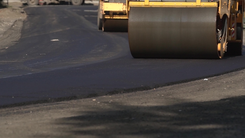 Roadway repair. Asphalt laying. The roller levels the newly laid asphalt. Industrial Royalty-Free Stock Footage #1061698132