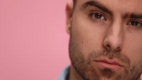 close up of attractive young man in blue shirt raising eyebrows, moving head and posing on pink background in studio. - Powered by Shutterstock - Get 15% off with code: PIKWIZARD15