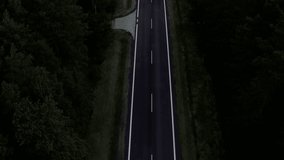 Flight Above A Two Lane Road With Cars In The Middle Of The Green Forest