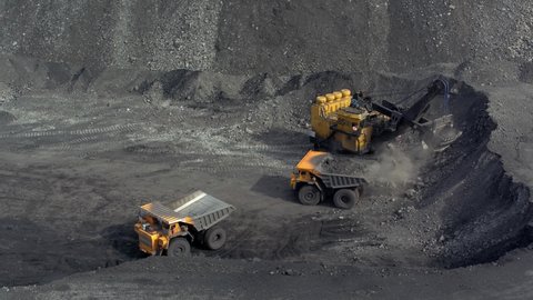 a large bucket excavator loads coal into a large dump truck 3