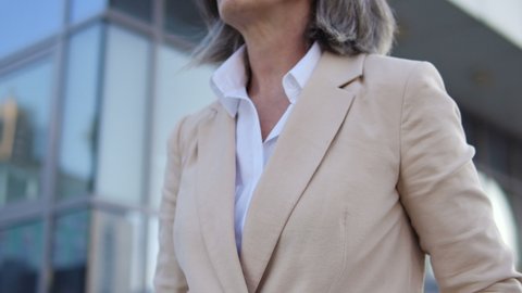 Mature business woman in suit holding hand chest, risk of heart attack or stroke